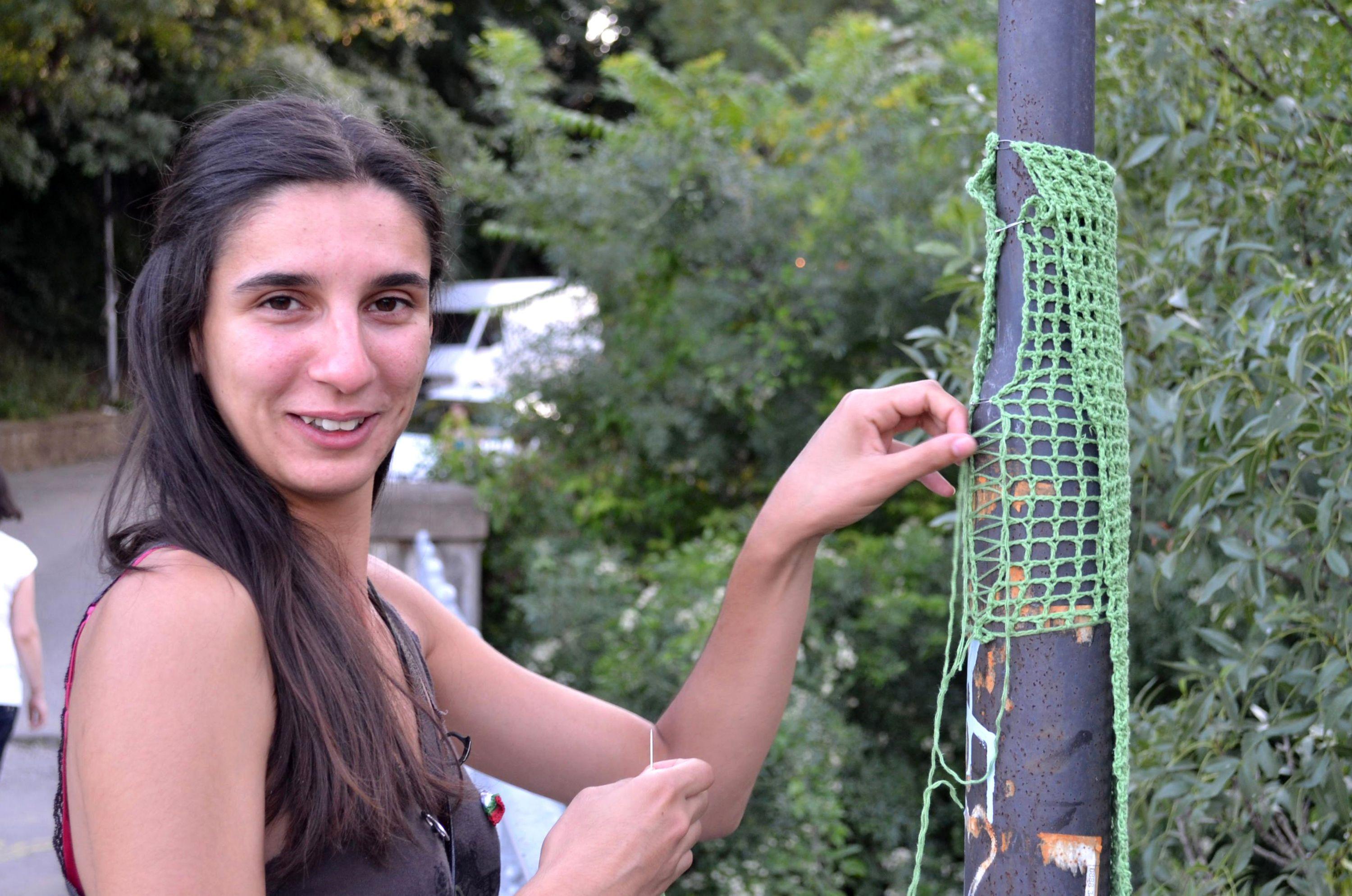 Момиче плете върху улични стълбове (СНИМКИ)