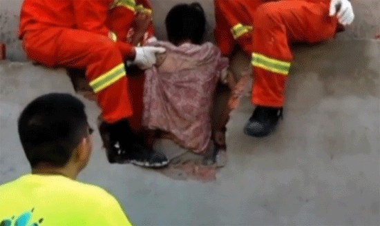 Китайка заседна между две огради, 7 часа я спасяват (ВИДЕО)