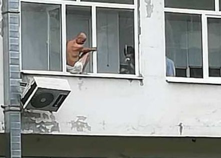 Ужас в Бургас! Над 3 часа полугол мъж виси на климатик и заплашва да скочи (СНИМКИ)
