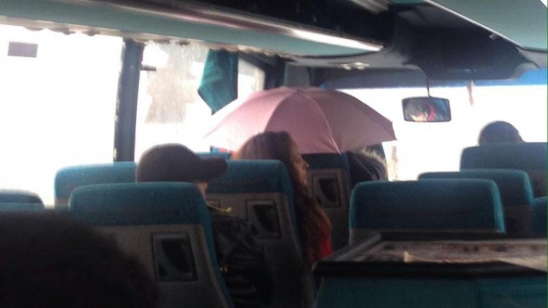 Дъжд заваля в междуградски автобус, пътничка стои с чадър, за да не се намокри (СНИМКА)