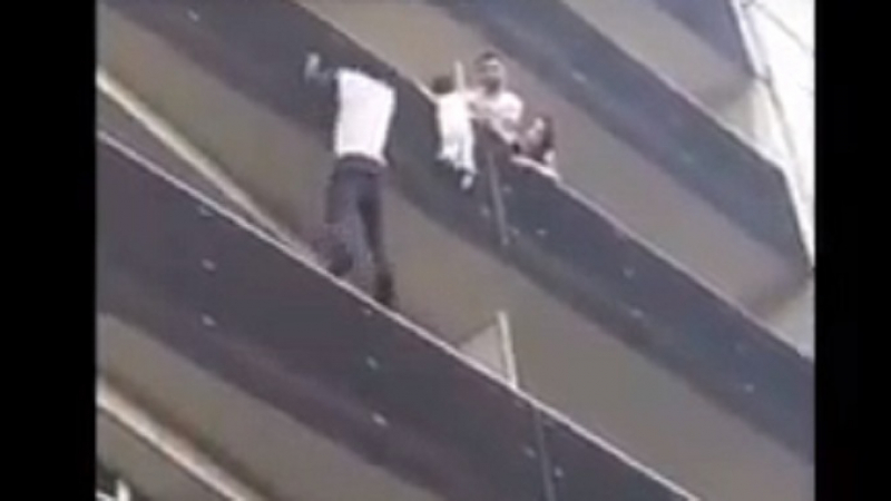 Мъж буквално действа като Спайдърмен и спаси висящо от балкон дете (ВИДЕО)