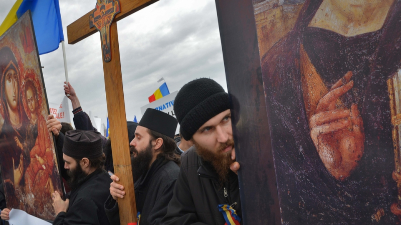 Свещеници гонят ваксинирани в Румъния, дърпат маските на вярващите