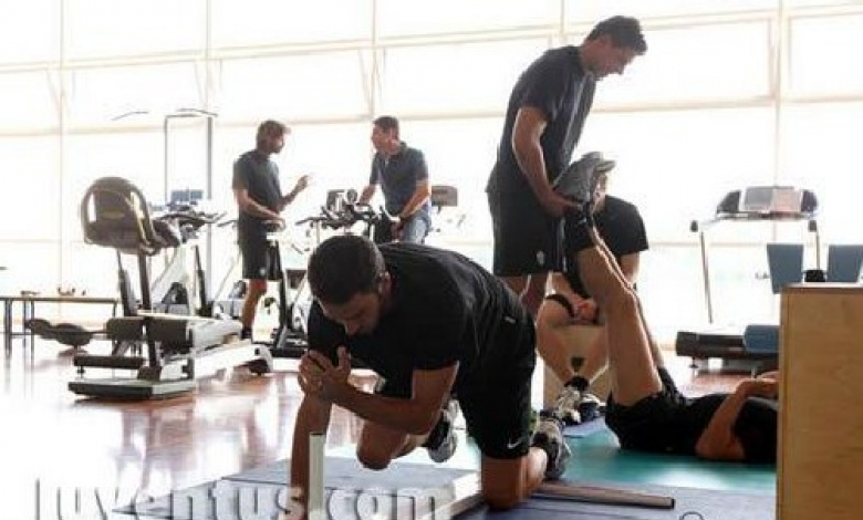 Марио Кирев държи краката на съотборник във фитнеса