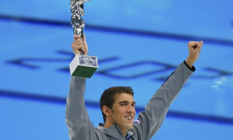 Майкъл Фелпс позира с наградата си за най-успешен олимпиец 