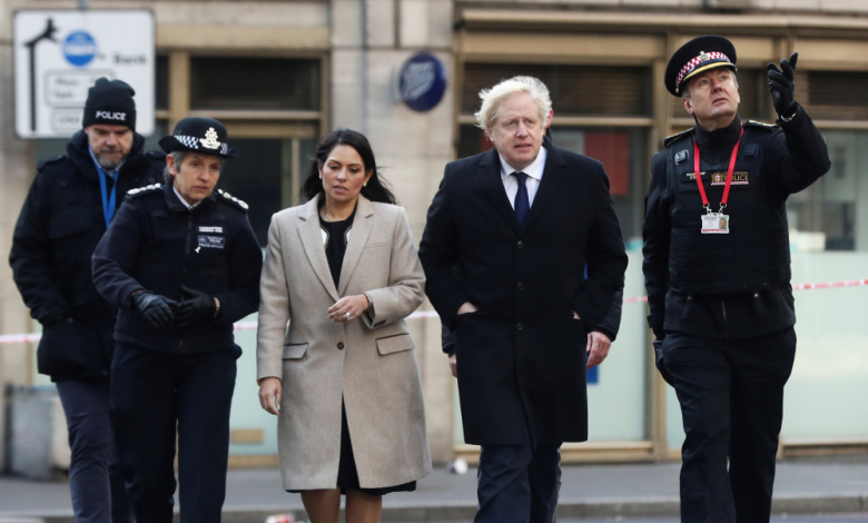 Прити Пател с премиера Борис Джонсън и група полицаи; снимка: Getty Images/Guliver