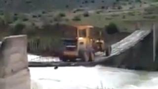 Невиждано: Грейдер преминава река по въжен мост (ВИДЕО)