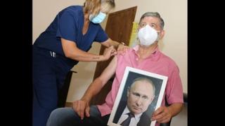 С портрет на Путин в ръце се ваксинира кмет на аржентински град