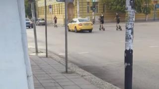 Деца с тротинетки в бясна гонка с такси ВИДЕО
