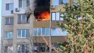 Огнеборци с противогази се борят с пожар в столичен блок